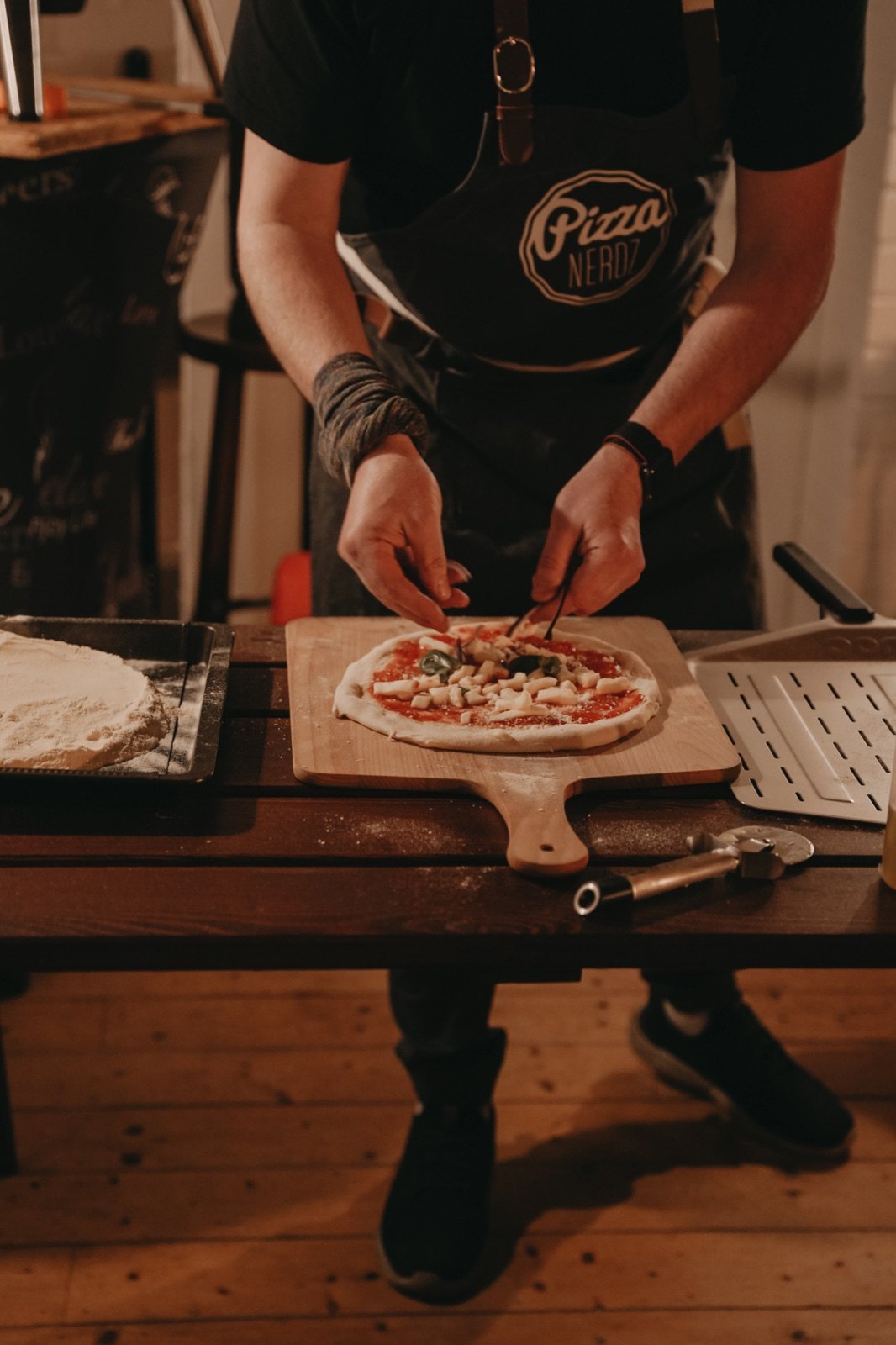 Rudi belegt eine Pizza mit Mozzarella.